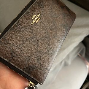 Brown Coach zip around phone wallet with wrist strap